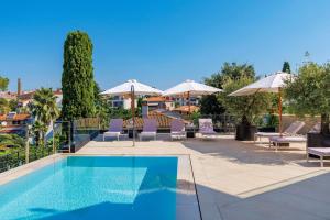 a swimming pool with chairs and umbrellas at Villa Albion in Rovinj +37 photos