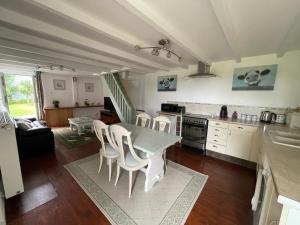 una cucina e una sala da pranzo con tavolo e sedie di Les Forges a Saint-Georges-de-Livoye