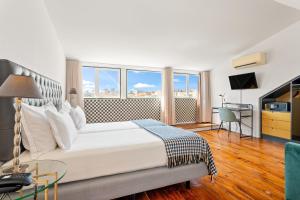 a bedroom with a large white bed and a desk at Casa do Jasmim by Shiadu in Lisbon