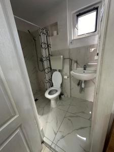 a white bathroom with a toilet and a sink at Casa Adriana Cluj-Napoca in Cluj-Napoca