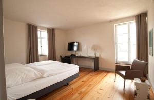 a bedroom with a bed and a desk and a television at Villa Behr in Wendlingen am Neckar