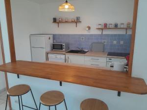 a kitchen with a wooden table and stools at Jolie maison à la campagne avec Spa et piscine in Bussac