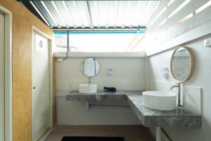 ein Badezimmer mit zwei Waschbecken und einem Spiegel in der Unterkunft TIDE & TRIBE HOSTEL Phangan in Thongsala