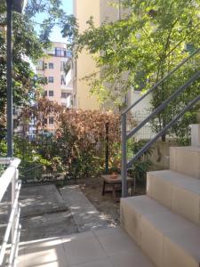 a garden with a fence and stairs and a bench at Ofellows - Kristal Center in Tirana
