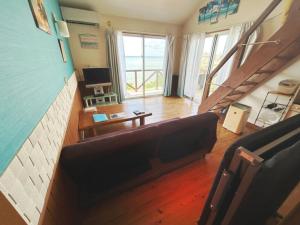 a living room with a couch and a stair case at ALOALO BEACH KABIRA - Vacation STAY 39179v in Fukai