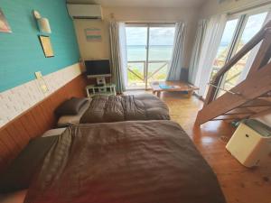 a bedroom with two beds and a view of the ocean at ALOALO BEACH KABIRA - Vacation STAY 39179v in Fukai