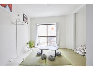 Cette chambre blanche dispose d'une table et d'une fenêtre. dans l'établissement Tora Hotel Kitaueno - Vacation STAY 52747v, à Tokyo