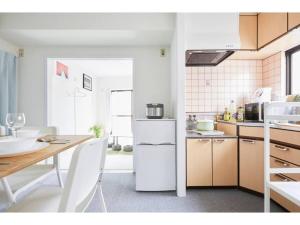une cuisine avec un réfrigérateur blanc et une table dans l'établissement Tora Hotel Kitaueno - Vacation STAY 52747v, à Tokyo