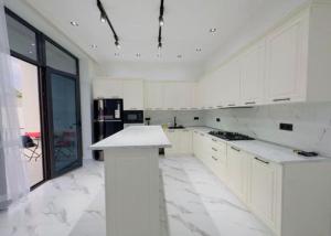 a kitchen with white cabinets and a white counter top at Süvalan in Baku