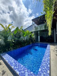 een blauw zwembad voor een huis bij Casa Serena Cemagi in Canggu