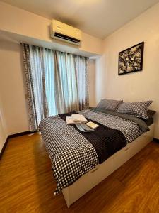 Ένα ή περισσότερα κρεβάτια σε δωμάτιο στο Metro Nook Cozy 2BR Unit with Balcony Facing Rockwell - Acqua Private Residences