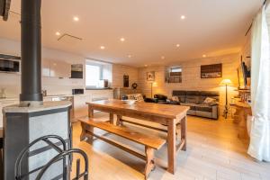 a kitchen and living room with a table and a stove at KLodge-Chalet Pyrénées- Sauna-Aventures Montagne in Vignec +6 photos