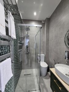 a bathroom with a shower and a toilet and a sink at Sands of Time Apart Hotel in Baku