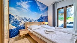 a bedroom with a large mountain mural on the wall at Resort Sudety, Sun & Snow in Szklarska Poręba