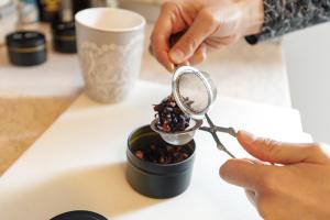 a person holding a magnifying glass over a container of food at Dolomitihouse ZIRMOL in Fiera di Primiero