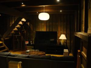 un salon avec un canapé et une télévision dans l'établissement 岡の里旅籠塩屋, à Taketa