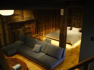 un salon avec un canapé et un lit dans l'établissement 岡の里旅籠塩屋, à Taketa