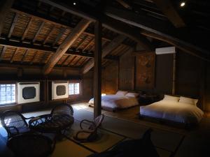 - une chambre avec 2 lits et 2 chaises dans l'établissement 岡の里旅籠塩屋, à Taketa