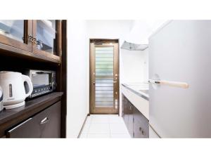 eine Küche mit Kühlschrank und Arbeitsplatte in der Unterkunft Fukugi Terrace - Vacation STAY 61841v in Bise