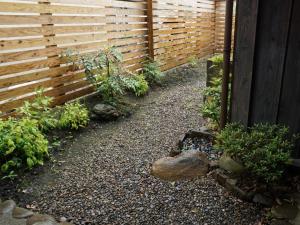 a garden with a wooden fence and a gravel path at Jisaburo Ozawa's residence - Vacation STAY 66110v in Saito +9 photos