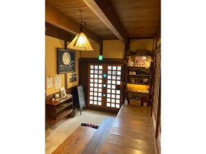 a living room with a wooden floor and a pendant light at Shima no Gochisō, Kominka Cafe to Yado Awa - Vacation STAY 66758v in Awaji