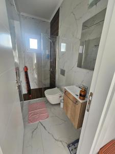 ein Badezimmer mit Dusche, Toilette und Waschbecken in der Unterkunft Luxury Apartment at Four Seasons Life 2 14-B in Vokolidha