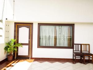 a room with a door and a chair and a window at Eastin Park in Navalur