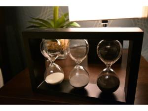 two clocks sitting on a table with a wooden box at Alphabed Takamatsu Furujinmachi - Vacation STAY 11905 in Takamatsu