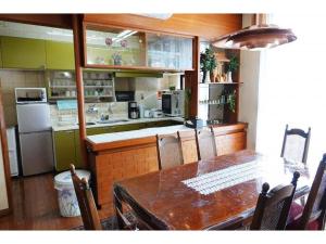 a kitchen with a wooden table and a table and chairs at THE TORII - Vacation STAY 68438v in Kumamoto +13 photos