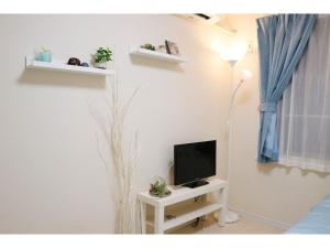 ein Wohnzimmer mit Fernseher und Tisch mit Lampe in der Unterkunft OHANA TOKYO HOUSE - Vacation STAY 73223v in Tokio