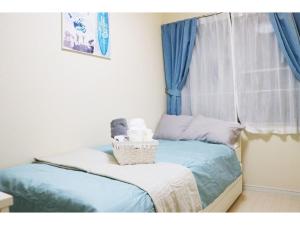 une chambre avec un lit avec une fenêtre avec des rideaux bleus dans l'établissement OHANA TOKYO HOUSE - Vacation STAY 73207v, à Tokyo