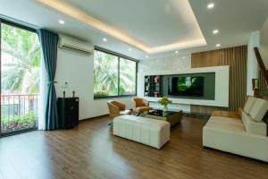 un soggiorno con un divano e una TV di Charme Villa nighstress flamingo Đải Lải Vĩnh Phúc a Kon Rung (1)