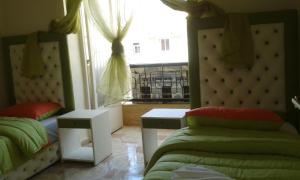 - une chambre avec 2 lits et une fenêtre avec vue dans l'établissement Hotel School Ersat Azrou, à Azrou