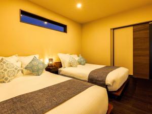 a hotel room with two beds and a window at Grace Villa Miyakojima - Vacation STAY 58441v in Uechi