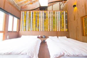 two beds in a room with a wall of logs at Machiya Villa Seian - Vacation STAY 11749 in Fukuoka