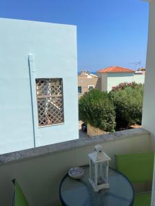 un tavolo in vetro con lanterna sul balcone di Maison à côté lac proche mer FANOU HOUSE a Georgioupoli
