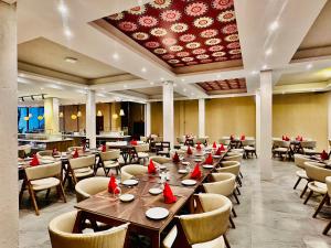 a dining room with tables and chairs and a ceiling at Hotel Alakamanda in Anuradhapura