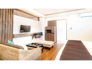 a room with a bed and a couch and a tv at Fukugi Terrace - Vacation STAY 61836v in Bise