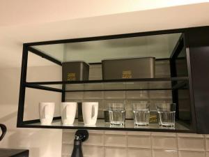 een plank met bekers en glazen aan de muur bij AOCA Kaminoge - Vacation STAY 11985 in Tokyo