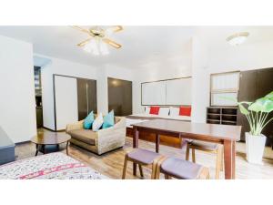a living room with a table and a couch at Fukugi Terrace - Vacation STAY 61828v in Bise