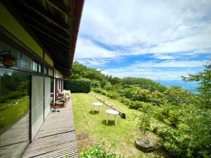a porch of a house with two chairs and a bench at Kiyo's Gokokuen "Tatsumado" - Vacation STAY 77728v in Kasama