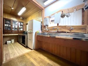 a kitchen with a sink and a refrigerator at Kiyo's Gokokuen "Tatsumado" - Vacation STAY 77728v in Kasama