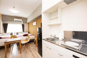 a room with a bed and a kitchen with a sink at STAYTUS - Vacation STAY 62189v in Kagoshima