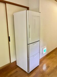 a white refrigerator in a room with a wooden floor at Kiyo's Gokokuen "Tatsumado" - Vacation STAY 06870v in Kasama
