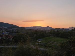 a sunset over a city with mountains in the background at ＬＯＤＧＥ ｎ"ｔｒｉｂｅ - Vacation STAY 79113v in Nichinan