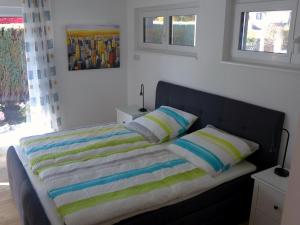 a bedroom with a bed with striped pillows at Ferienwohnung Am Hochrhein in Murg
