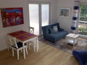 a living room with a table and a blue couch at Ferienwohnung Am Hochrhein in Murg