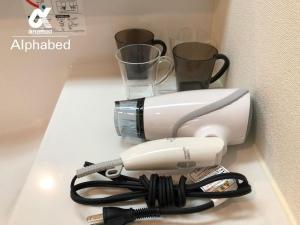 a white blender sitting on a counter with two cups at Alphabed Takamatsu Furujinmachi - Vacation STAY 11907 in Takamatsu