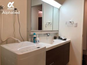 a bathroom with a sink and a mirror at Alphabed Takamatsu Furujinmachi - Vacation STAY 11907 in Takamatsu +24 photos