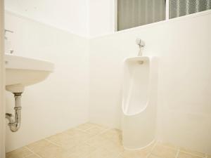 a white bathroom with a urinal and a sink at Mcity in Maejima - Vacation STAY 54881v in Naha